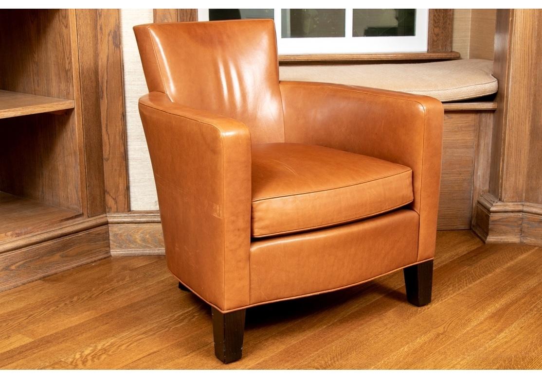 A stylish and very comfortable leather club chair with rounded form that conjoins with a squared off backrest that flows from top to bottom, straight arms that are covered in one piece from back cascading to the bottom of the chair. Designed by