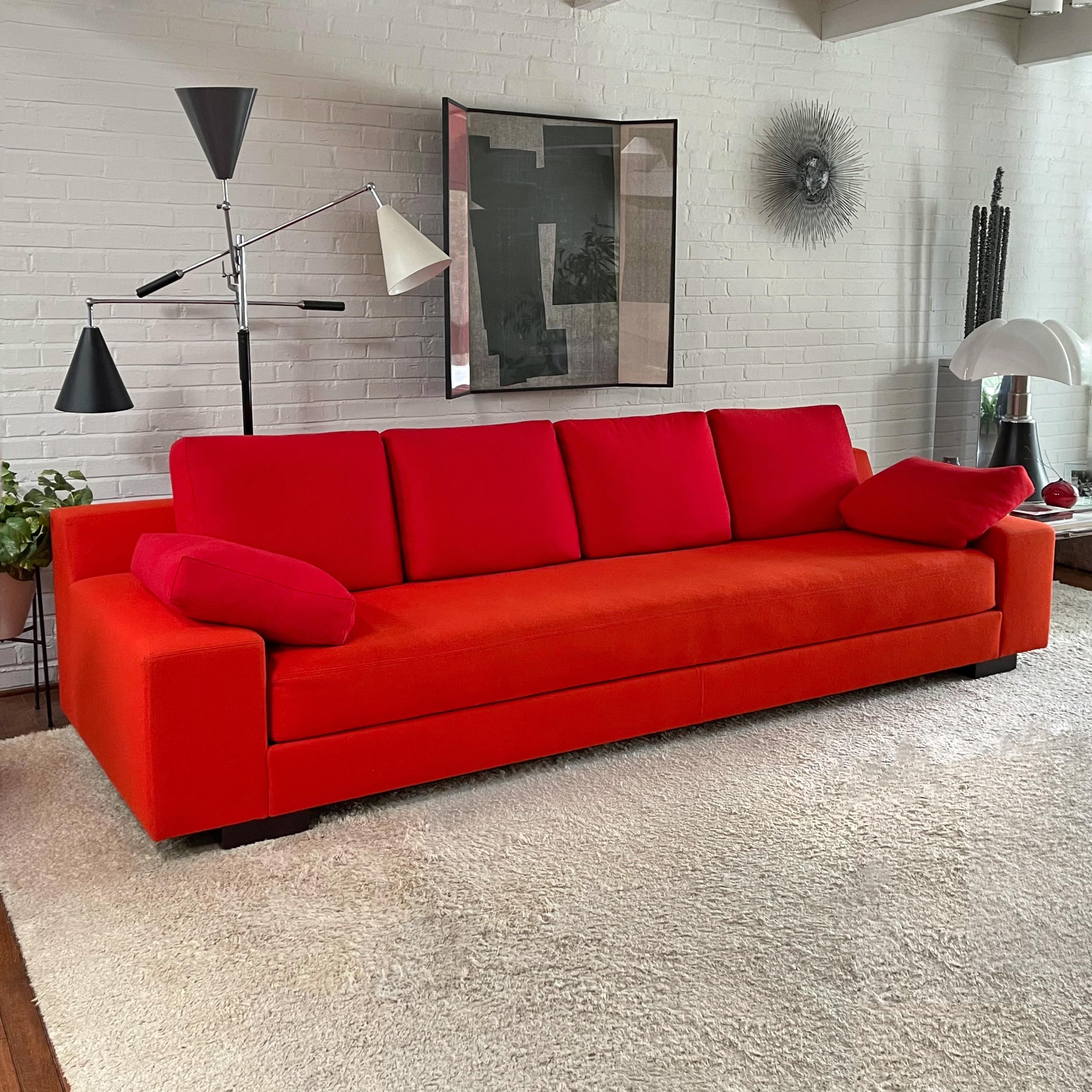 Large, lush, and lovely, this stunning sofa by Christian Liaigre for Holly Hunt is deep, comfortable, and stylish. Upholstered in a vivid red-orange felted wool fabric, possibly Davina by Maharam, it is a statement piece for those that don't fear