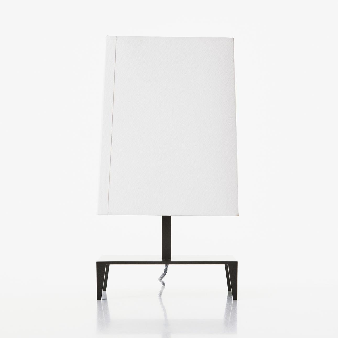 A vintage “Galerie” accent lamp designed by Christian Liaigre. 
The lamp was produced in the late 1990s / early 2000s, the design is currently discontinued. 
The lamp base and stem are bronze painted metal, the original lamp shade is off white