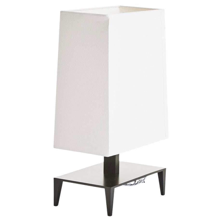 A vintage “Galerie” accent lamp designed by Christian Liaigre. 
The lamp was produced in the late 1990s / early 2000s, the design is currently discontinued. 
The lamp base and stem are bronze painted metal, the original lamp shade is off white
