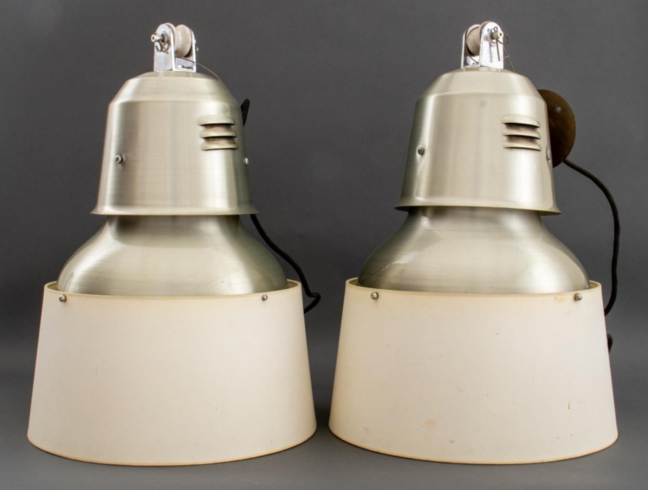 Christian Liaigre (French, 1943-2020) Mercer Kitchen (designed 1997) stainless steel industrial pendant lights with custom paper shades by Liaigre, featuring a conical form with white porcelain pulleys, and circular shades. 24