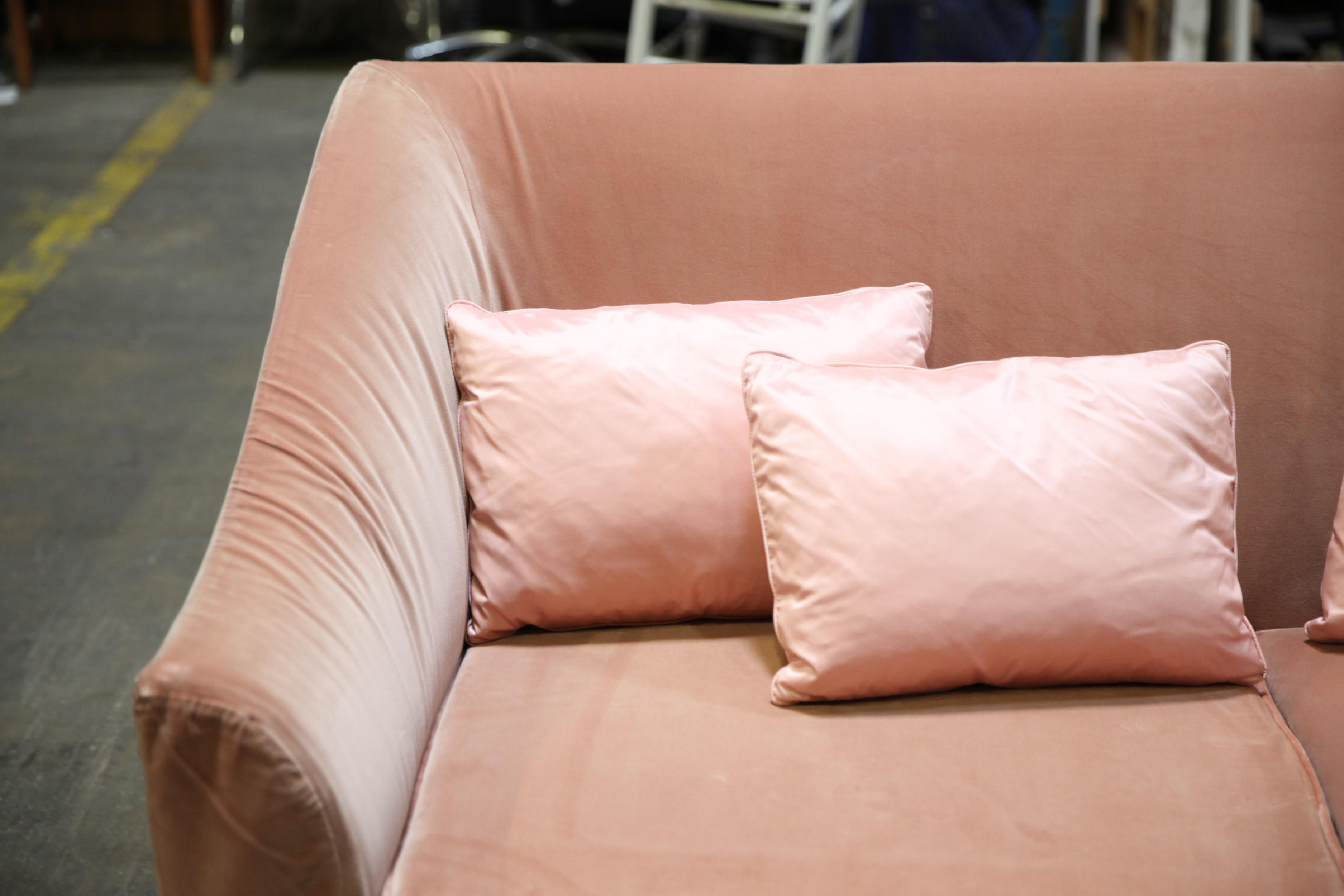 Modern sofa upholstered in pink velvet, designed by Christian Liaigre. The piece has an all-over velvet covering and comes with four throw pillows. In great vintage condition with age-appropriate wear and use to the Velvet.