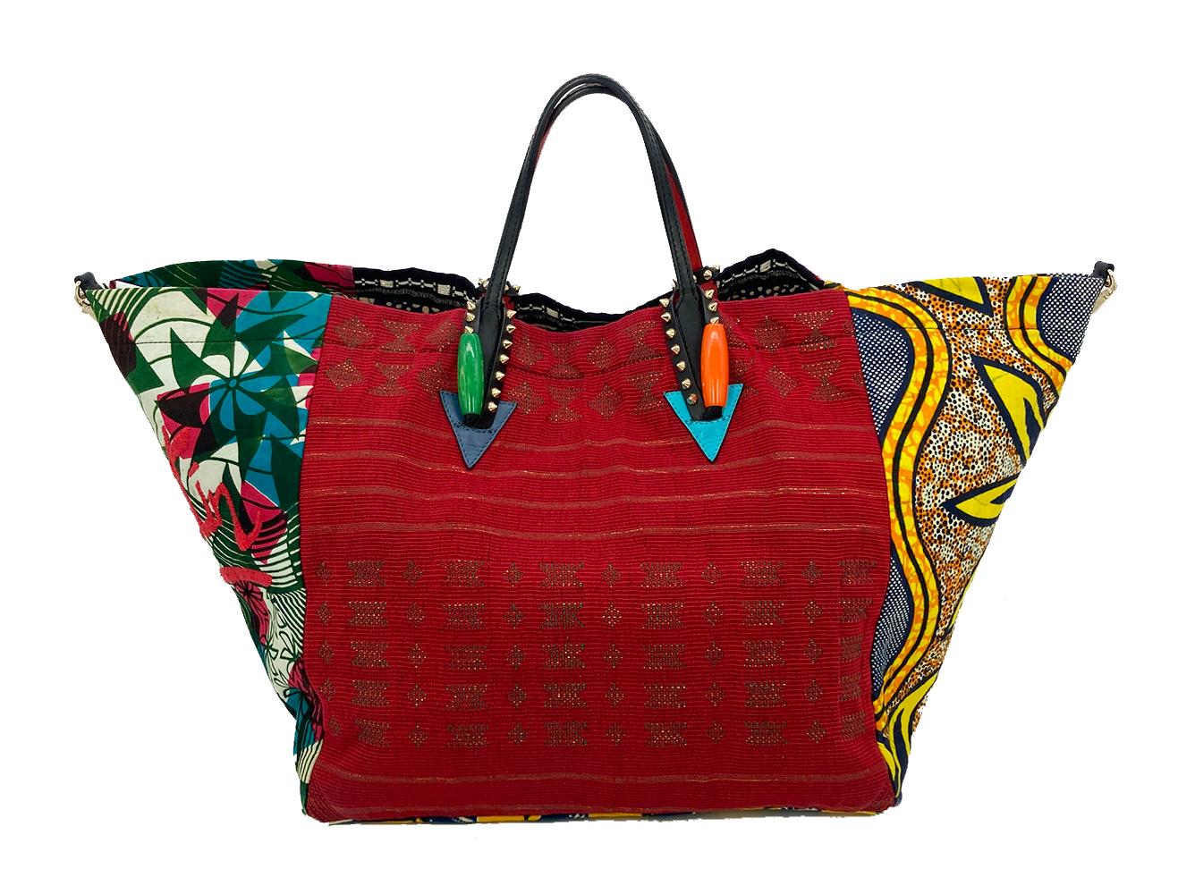Christian Louboutin Africaba Cotton Tote in good condition. Colorful ankara cotton print body with black leather top handles and a removable shoulder strap. Beaded embroidered CL patch on front side and wood bead and metal stud details along base of