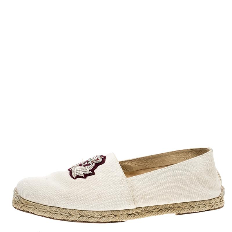 These Papi Hugo espadrilles by Christian Louboutin combines comfort with style. Crafted from beige canvas, these shoes feature round toes, embroidered logo crest detail on the vamps, espadrille midsoles, and the signature red soles. The insoles are