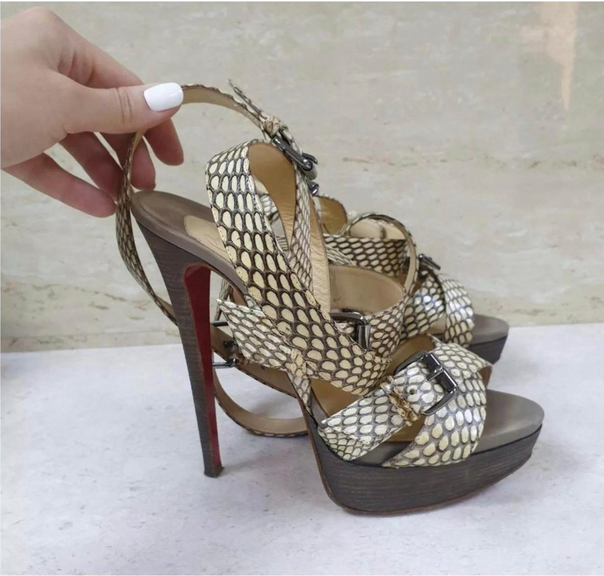Bold yet feminine, this pair of platform sandals reflect Louboutin’s design aesthetic. They feature the iconic red soles and are complemented by strappy uppers and 14 CM HEELS. They are given a cobra skin finish and accented with silver-tone