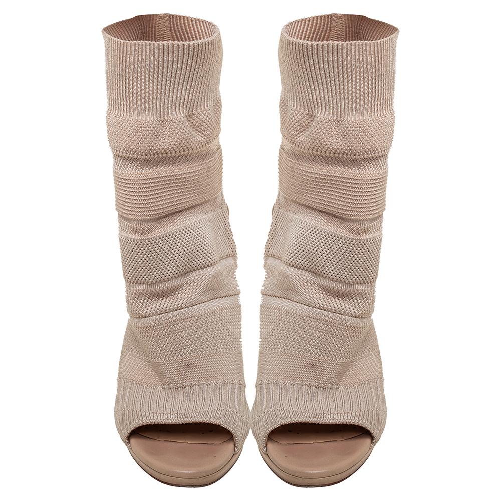 Christian Louboutin's Cheminene Maille boots define the power of modern women with utter grace. Crafted in beige knit fabric, the pair is fashioned in a mid-calf style, which is sure to add a dramatic touch to your look. They have a sock-like