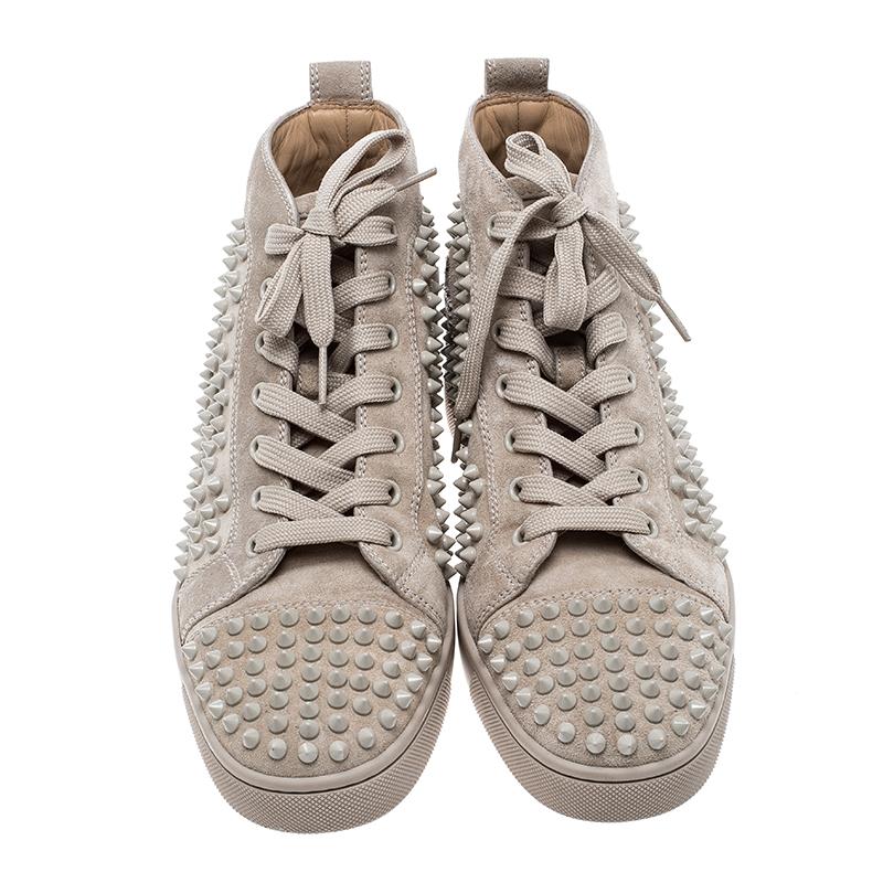 Feel and look great in your casual wear every time you step out in these sneakers from Christian Louboutin. They've been crafted from leather and styled as a high top with exteriors lined with spikes. The beige sneakers carry round toes, lace-up
