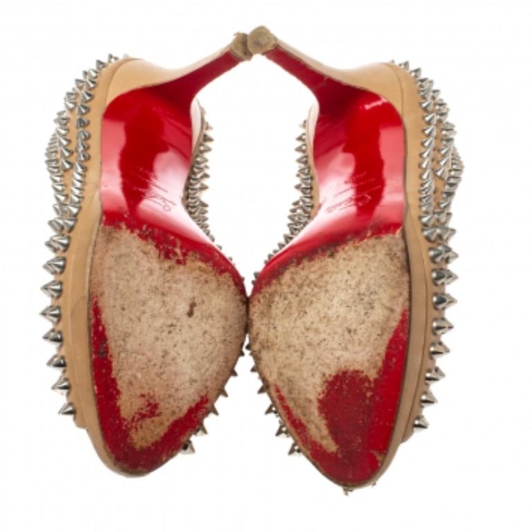 Make the streets your fashion runway and dazzle the crowds in these gorgeous Yolanda pumps from Christain Louboutin! The beige pumps have been crafted from leather and styled with peep-toes and multiple spikes on the exterior. They come equipped