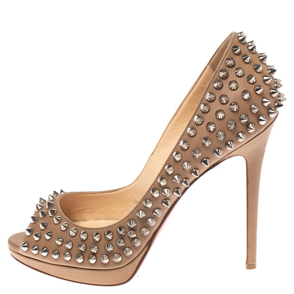 Make the streets your fashion runway and dazzle the crowds in these gorgeous Yolanda pumps from Christain Louboutin! The beige pumps have been crafted from leather and styled with peep-toes and multiple spikes on the exterior. They come equipped