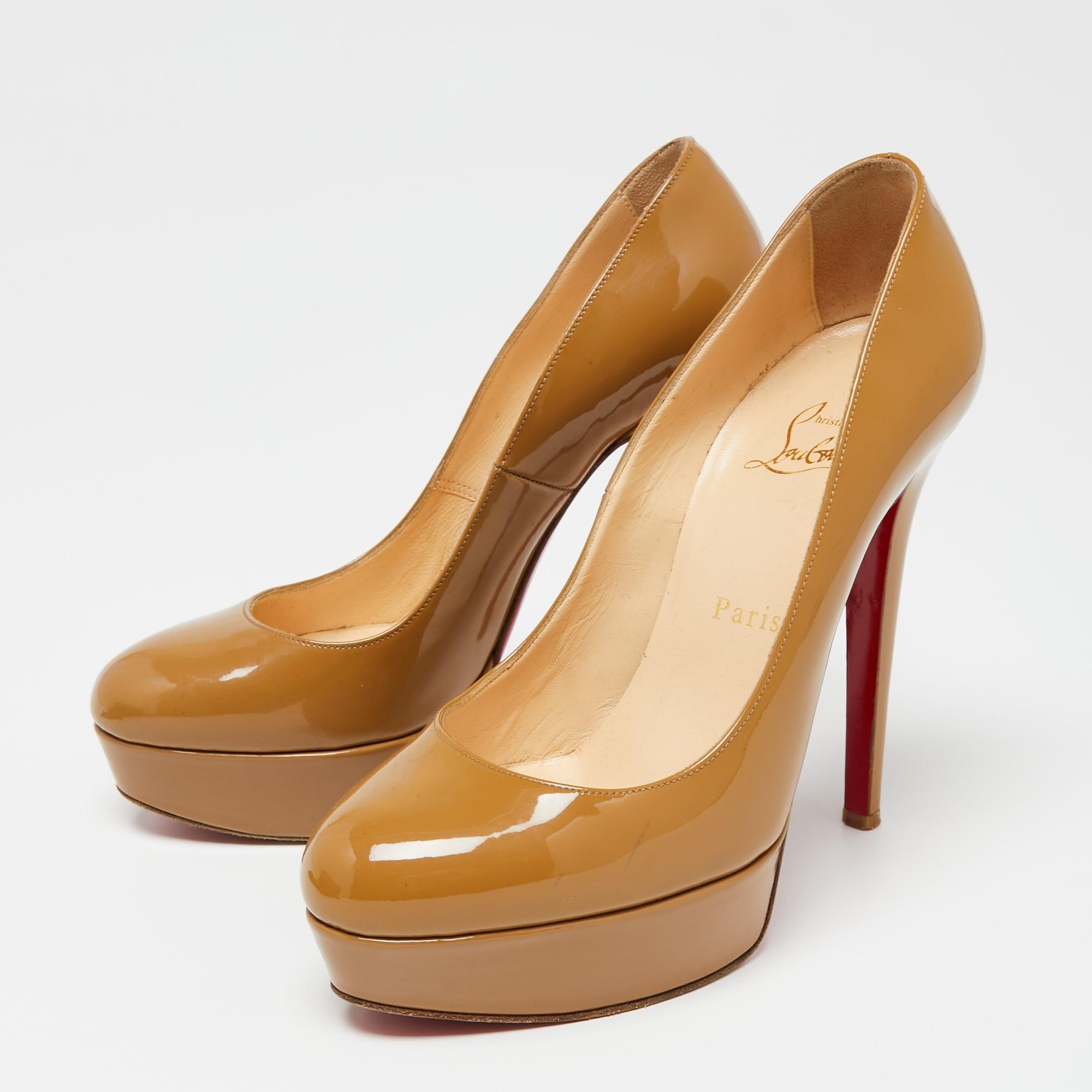 A classic to add to one's shoe collection is this pair of pumps. These Christian Louboutin beauties are covered in patent leather and are styled with platforms, 12.5 cm heels, and signature red soles. Add these beige pumps to your closet today and