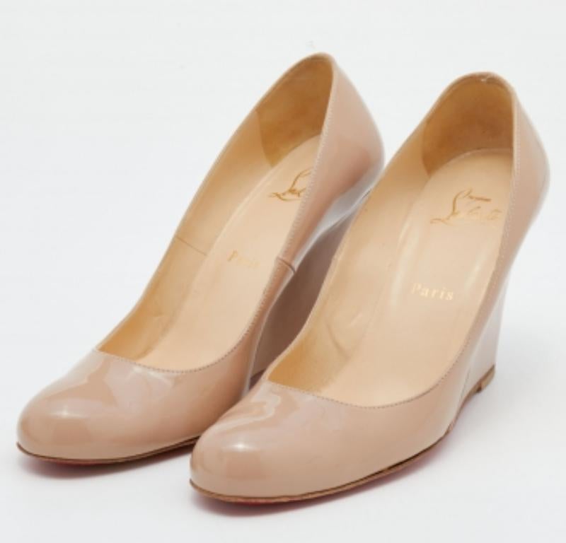 De diseño minimalista, este par de zapatos de salón Christian Louboutin es un espectáculo de pura belleza. La característica suela lacada en rojo y los tacones de cuña de estos zapatos reflejarán sofisticación a cada paso. Confeccionados en charol,