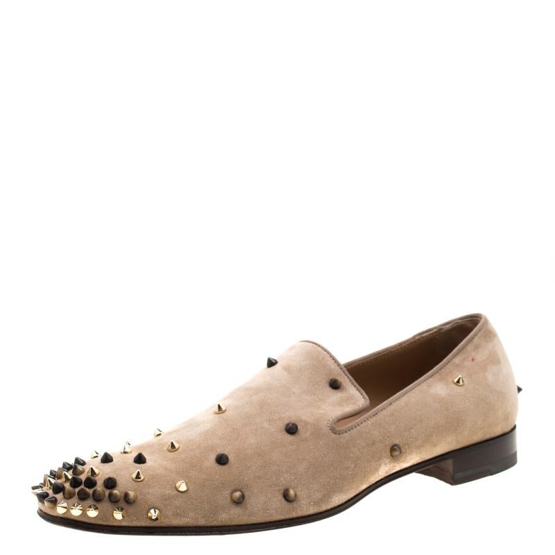 Add an edge to your look with this pair of Christian Louboutin Spike loafers. The beige loafers are crafted from suede and styled with round toes and multiple spikes detailed on the vamps and the heel counters. Comfortable leather lined insoles and