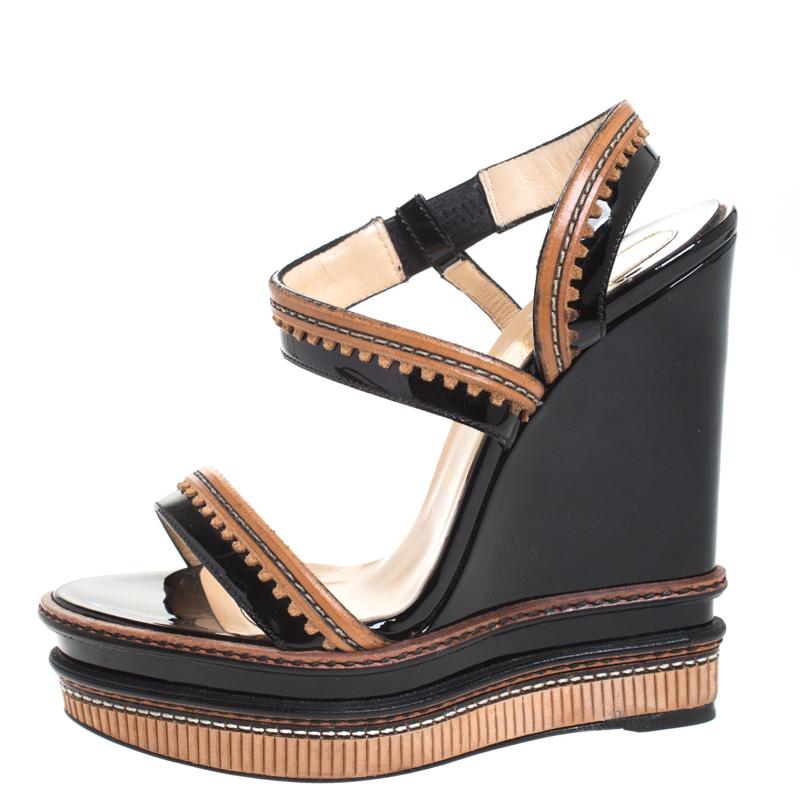 Stay comfortable throughout the day in these sandals by Christian Louboutin. This gorgeous pair of sandals made of patent leather will add a luxe touch to your look. Flaunt your stylish best side with these wedge sandals.

Includes: The Luxury