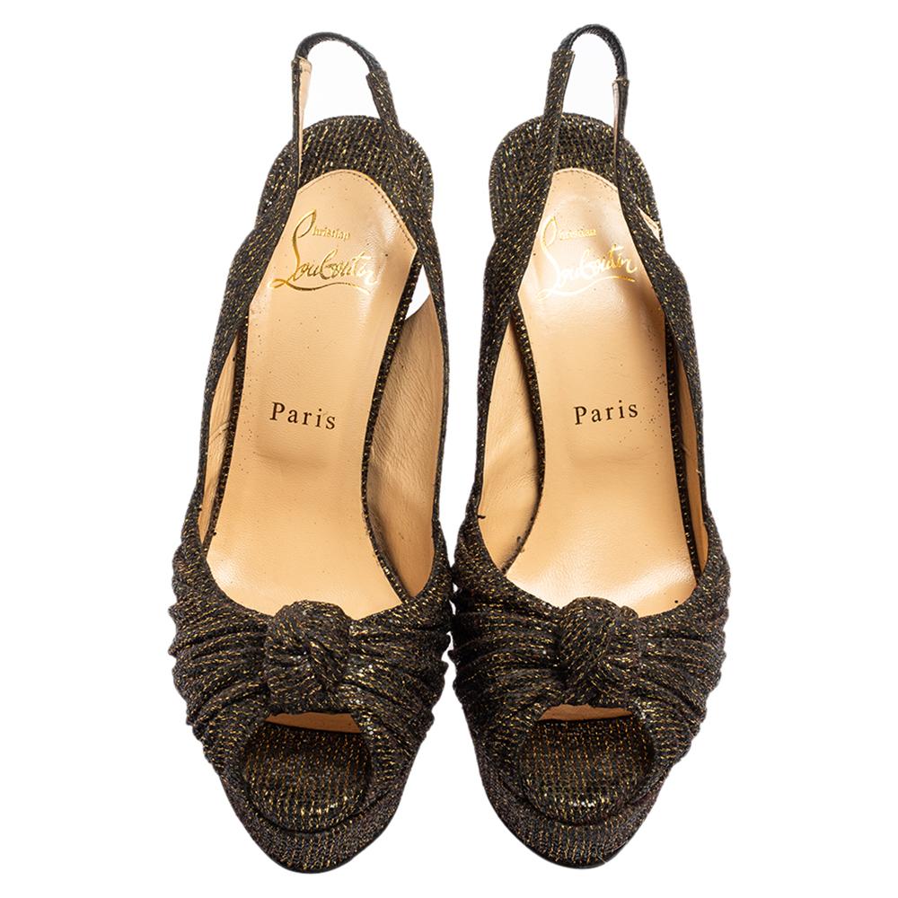 You wouldn’t wish to miss this astounding pair of Jenny platform sandals from Christian Louboutin. Crafted in Italy, they are made of glitter fabric and have black & gold hues. They are styled with knotted vamps and have an open-toe silhouette. This