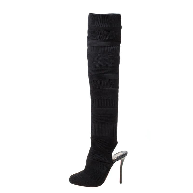 Christian Louboutin's Cheminetta boots define the power of modern women with utter grace. Crafted in black knit fabric, the pair is fashioned in a thigh-high style, which is sure to add a dramatic touch to your look. They have a sock-like silhouette