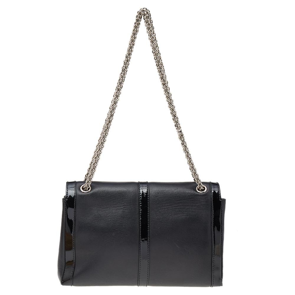 This modern Sweet Charity bag is a classic creation from Christian Louboutin. Crafted from black patent leather & leather, the bag comes with a signature bow detail on the front. The insides are fabric-lined and the bag is complete with a chain link