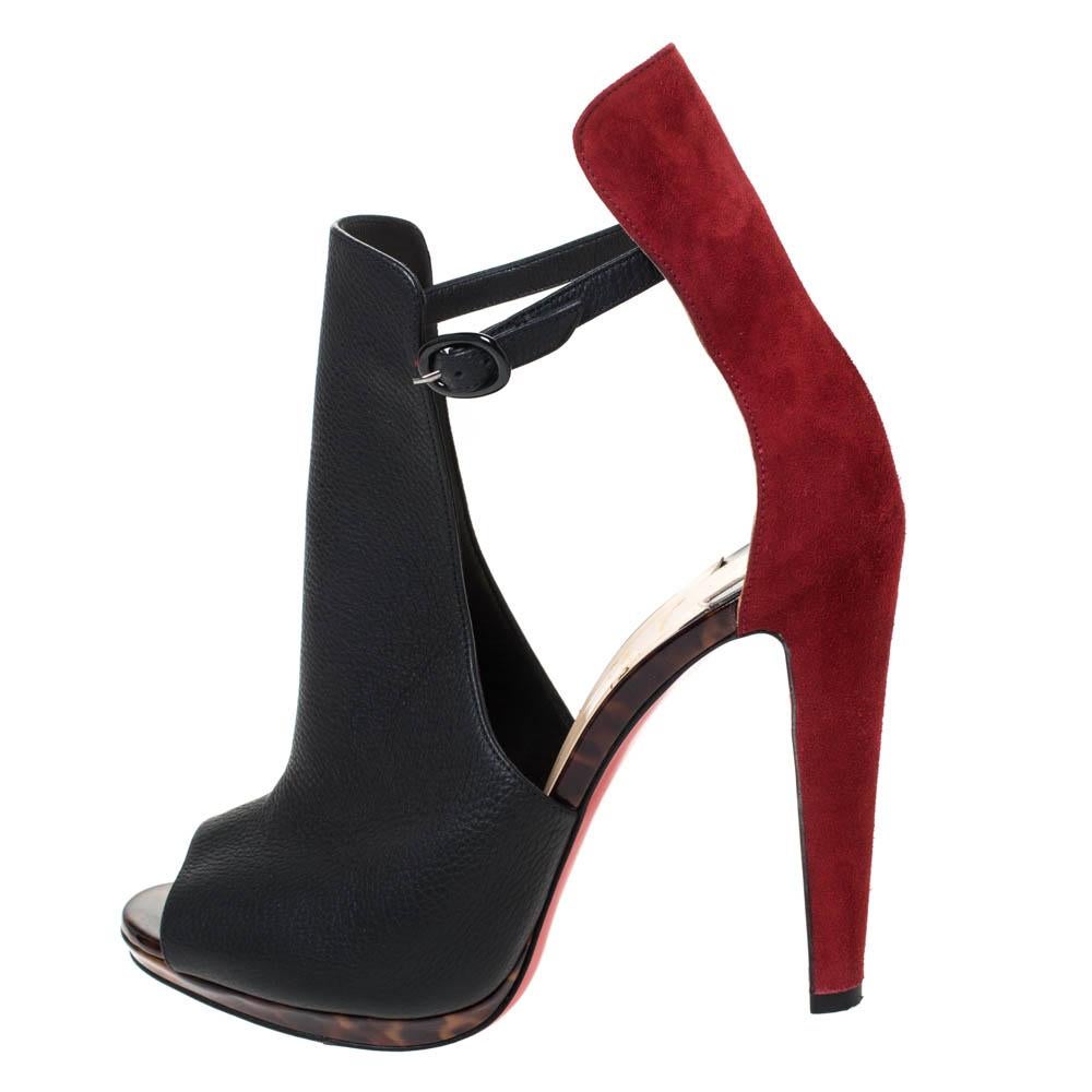 These black ankle boots by Christian Louboutin showcases a decadent resemblance. Crafted from leather and suede, they feature open toes along with unique cutout detailing. The ankle straps are accompanied by buckle fastenings. They come with