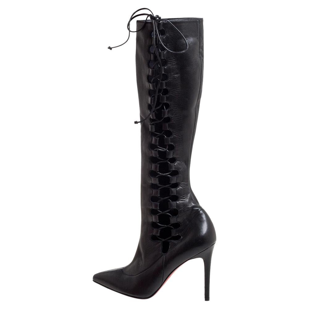 This bold yet chic pair of Christian Louboutin boots has a stylish silhouette and simple design. The knee-high boots have been crafted from black leather and feature lace-up panels on the sides. Representing the power dressing of modern women, these