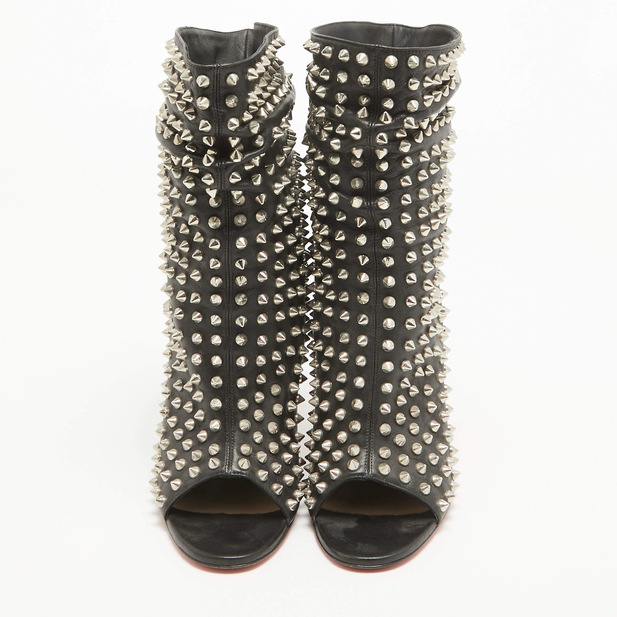 Bring out the rocker chic in you and stand out to make a statement wearing these stunning Christian Louboutin Guerilla ankle boots. Crafted in black leather with silver-tone spiked details all over, these shoes feature a slouchy design at the ankles
