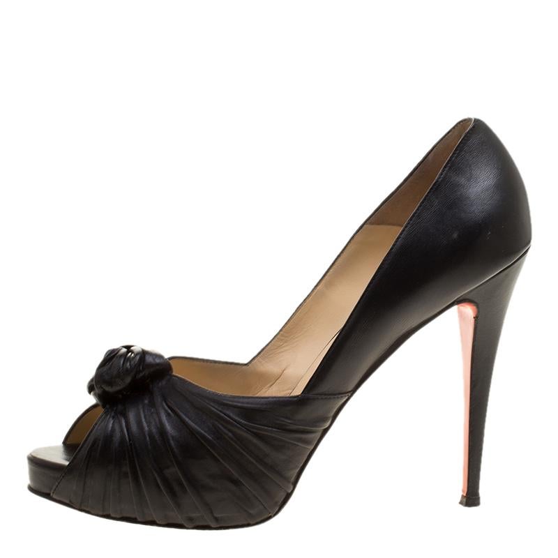 These Christian Louboutin pumps are simply stunning! They are crafted from black leather and styled with peep toes, ruched knot detailing in the vamps and 13 cm heels to lift you beautifully. The pumps are given a finishing touch with the signature