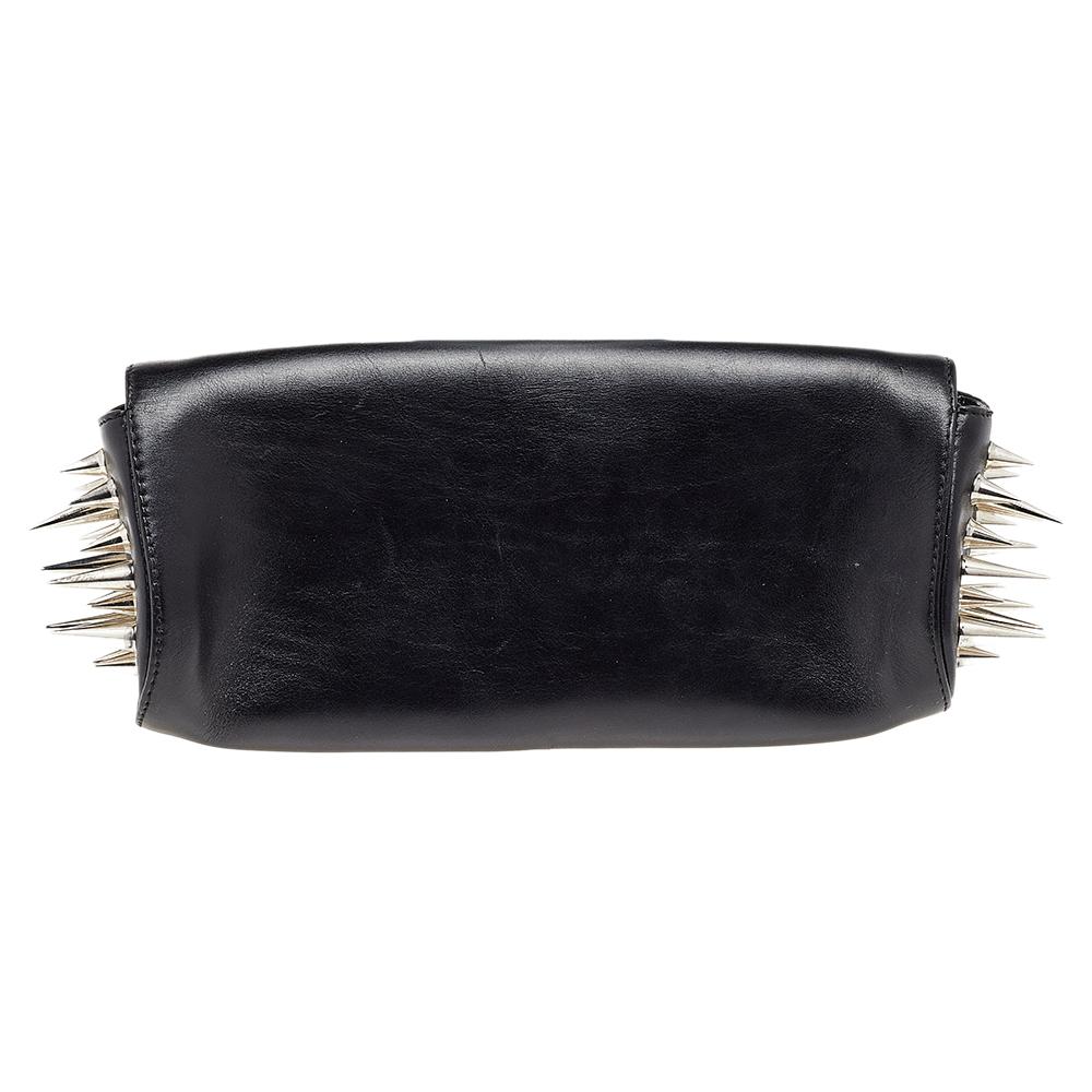 A trendy and fun update to a women's clutch is this Marquise by Christian Louboutin. Crafted from quality leather, the flap clutch has a smooth construction contrasted with signature spike detailing on the sides. The interior is lined with red-hued