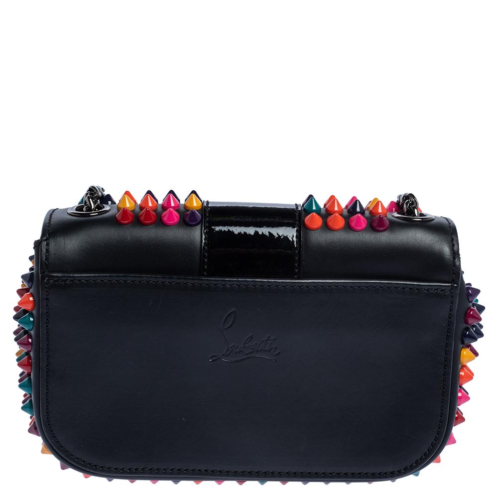 This modern Sweet Charity bag is from Christian Louboutin. Crafted from black leather, the bag comes with eye-catching spike embellishments and signature Loubi bow detail. The insides are fabric-lined and the bag is complete with a shoulder
