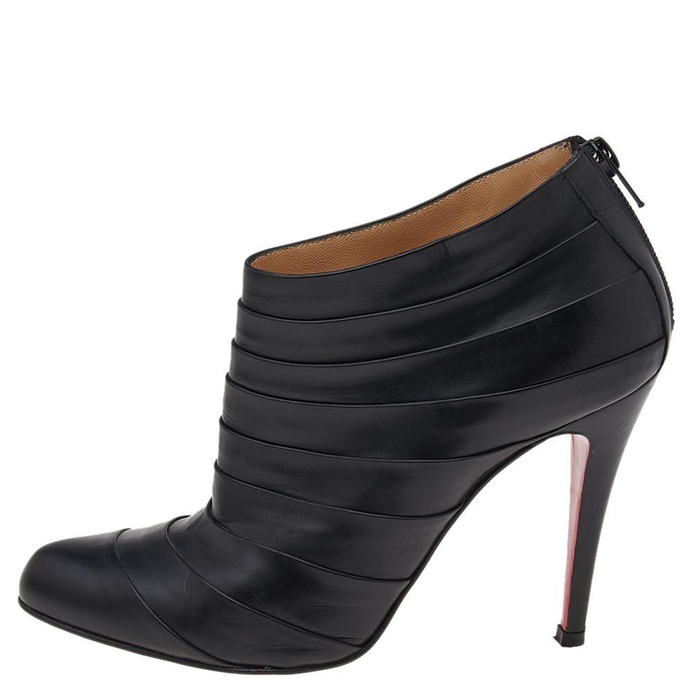 These Christian Louboutin ankle boots are a perfect amalgamation of comfort, style, and class! The black leather construction takes the form of an almond toe silhouette that is enhanced with zippers and pleated designs. The insoles are lined with