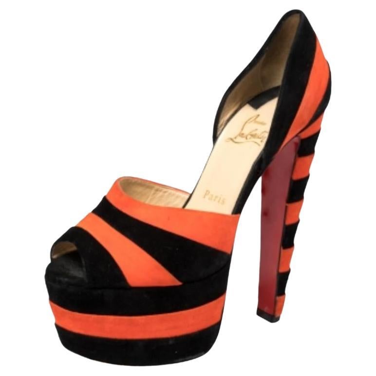Look stunning when you walk in these sandals by Christian Louboutin. Crafted from suede in black and orange hues, they a striped pattern all over. These peep-toe sandals are set on 15 cm heels supported platforms. Wear these beauties to interrupt a