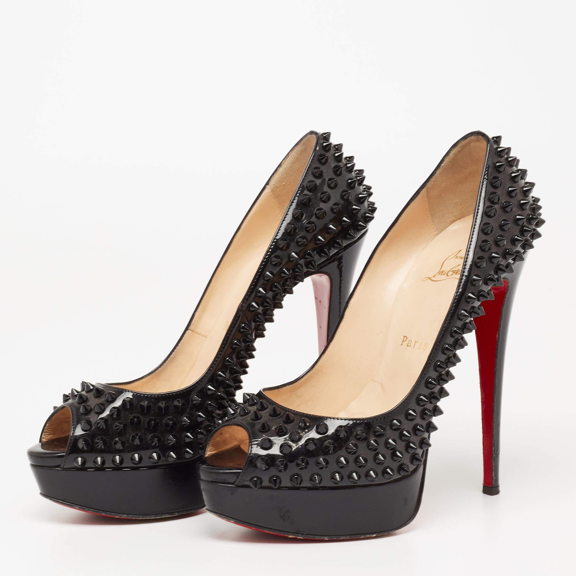 Christian Louboutin brings an element of class to your closet with these stunning Lady Peep pumps. They are created using black patent leather, which is highlighted with spike embellishments. They showcase peep toes, tall heels, and a slip-on