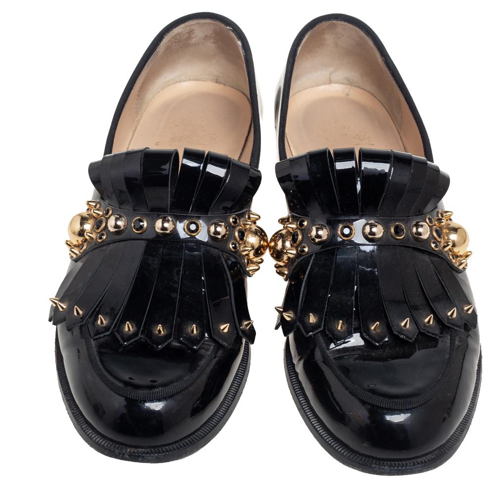 Christian Louboutin's patent-leather shoes come in a loafer-style design that's adorned with gold-tone metal studs of differing sizes on the fold-over fringe panel. They're made in Italy with a 1960s-inspired square toe and correlating small heel