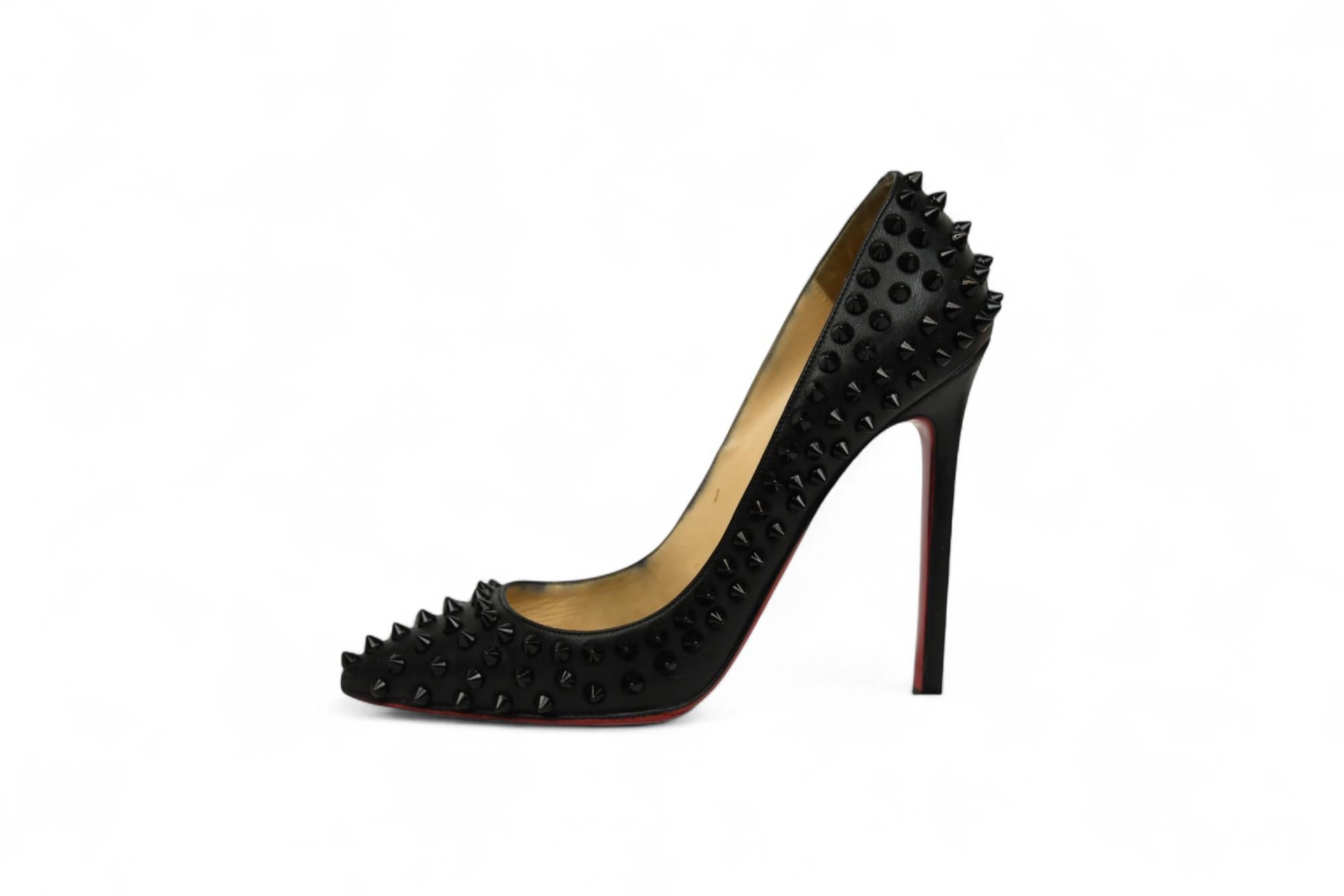 Add a bold edge to your luxury wardrobe with these Christian Louboutin Follies Spikes pumps, a fierce take on the iconic stiletto silhouette. Crafted in Italy from smooth black leather and covered in tonal black spikes, these pumps balance punk