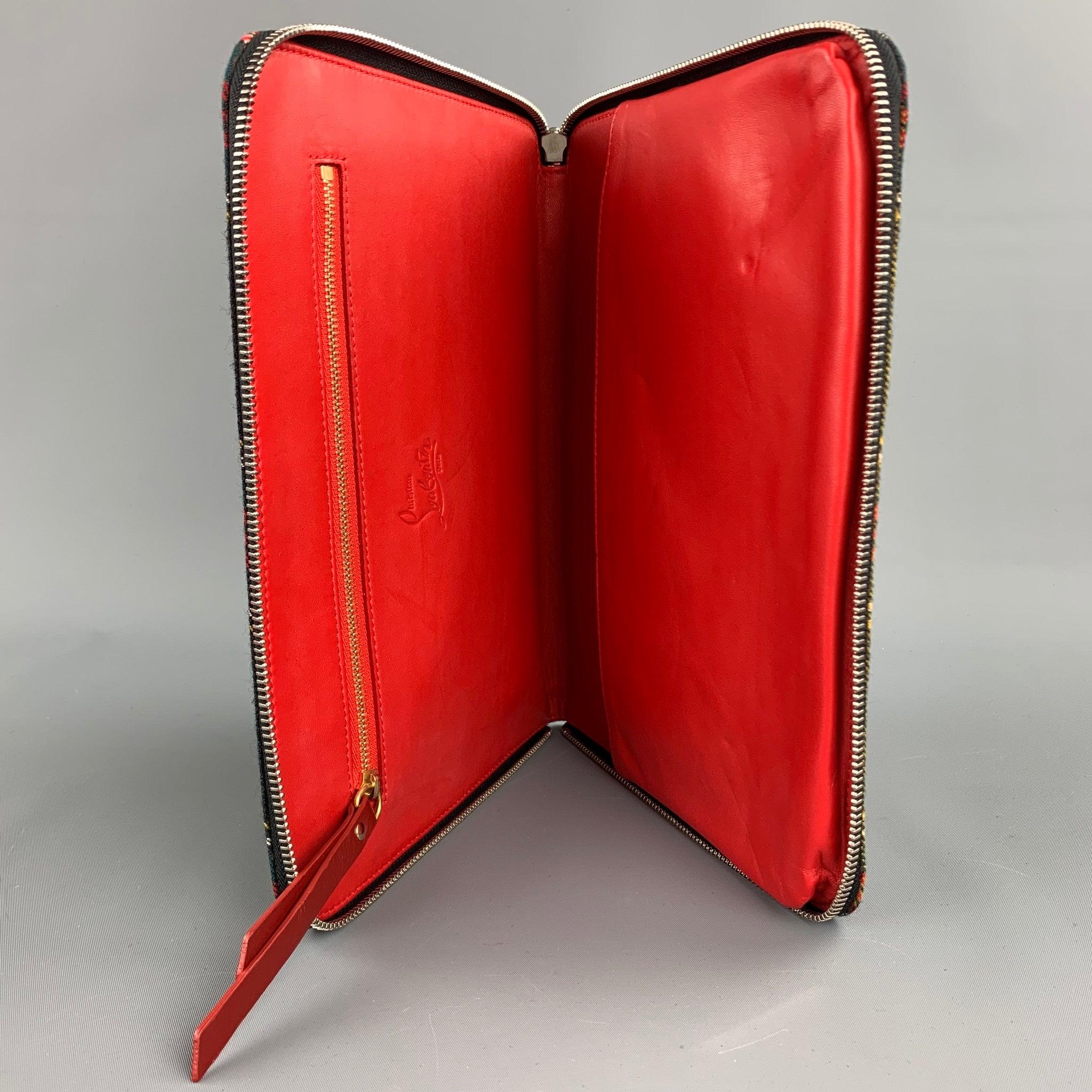 CHRISTIAN LOUBOUTIN iPad Case comes in a black & red plaid canvas with all over spike details featuring a leather strap, inner pocket, and a zip up closure. Fits a regular iPad.Very Good
Pre-Owned Condition. 

Measurements: 
  Length: 8 inches 