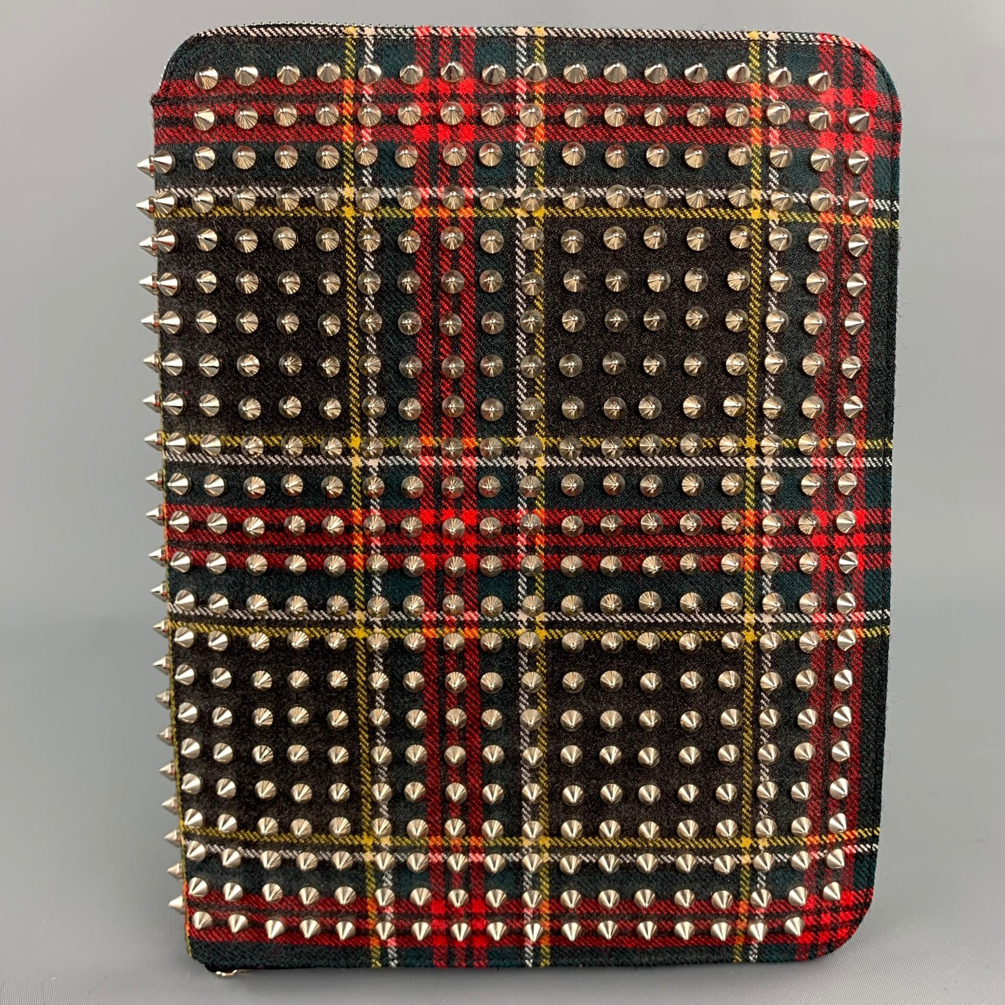 CHRISTIAN LOUBOUTIN iPad Case comes in a black & red plaid canvas with all over spike details featuring a leather strap, inner pocket, and a zip up closure. Fits a regular iPad.

Very Good Pre-Owned Condition.

Measurements:

Length: 8 in.
Height: