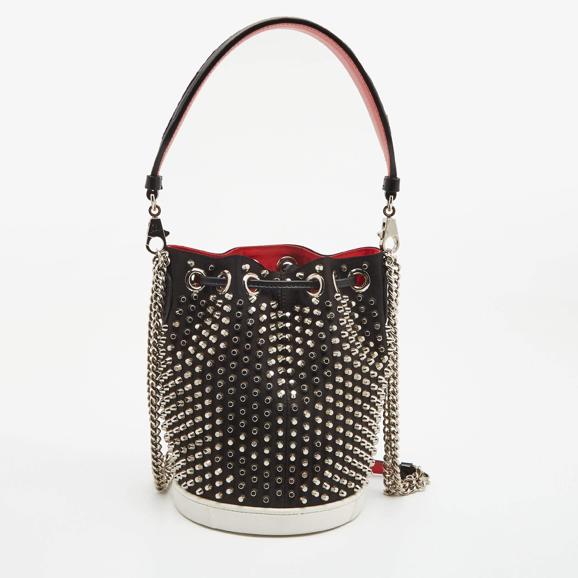 This functional bucket bag has been designed from a leather body secured with a drawstring top. It comes detailed with a shoulder strap and studs on the exterior. This bag is adorned with silver-tone hardware. Carry your everyday essentials in the