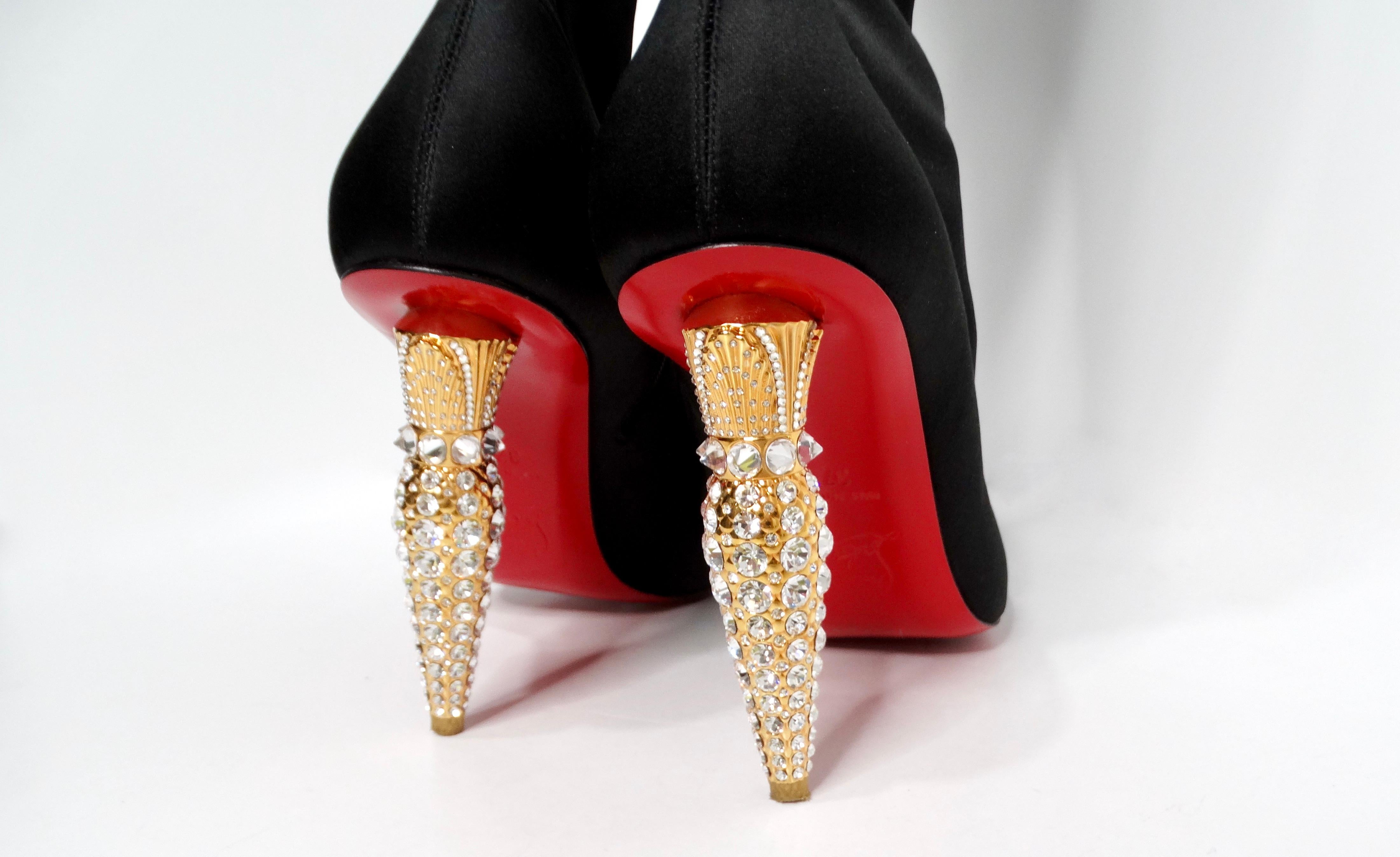 Introducing the epitome of elegance and glamour: the Christian Louboutin Black Silk Lipstrass Thigh-High Boots. These striking boots showcase a luxurious black silk fabric that effortlessly hugs the legs, accentuating every curve. The highlight of