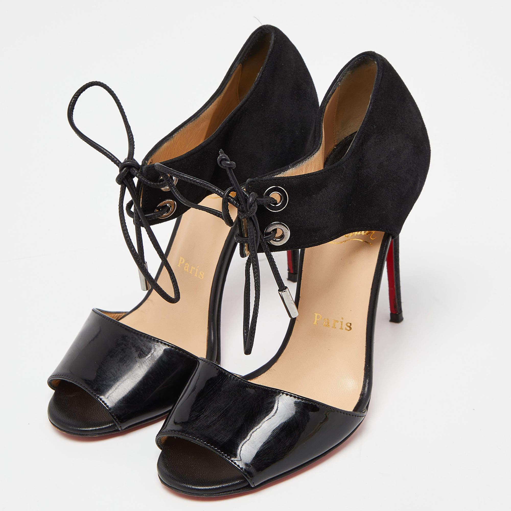 Cette paire de sandales de Christian Louboutin est d'une grande sophistication. Ces chaussures sont fabriquées en daim et en cuir verni, dans une teinte noire très chic, et sont dotées de lacets et de talons de 10 cm.

