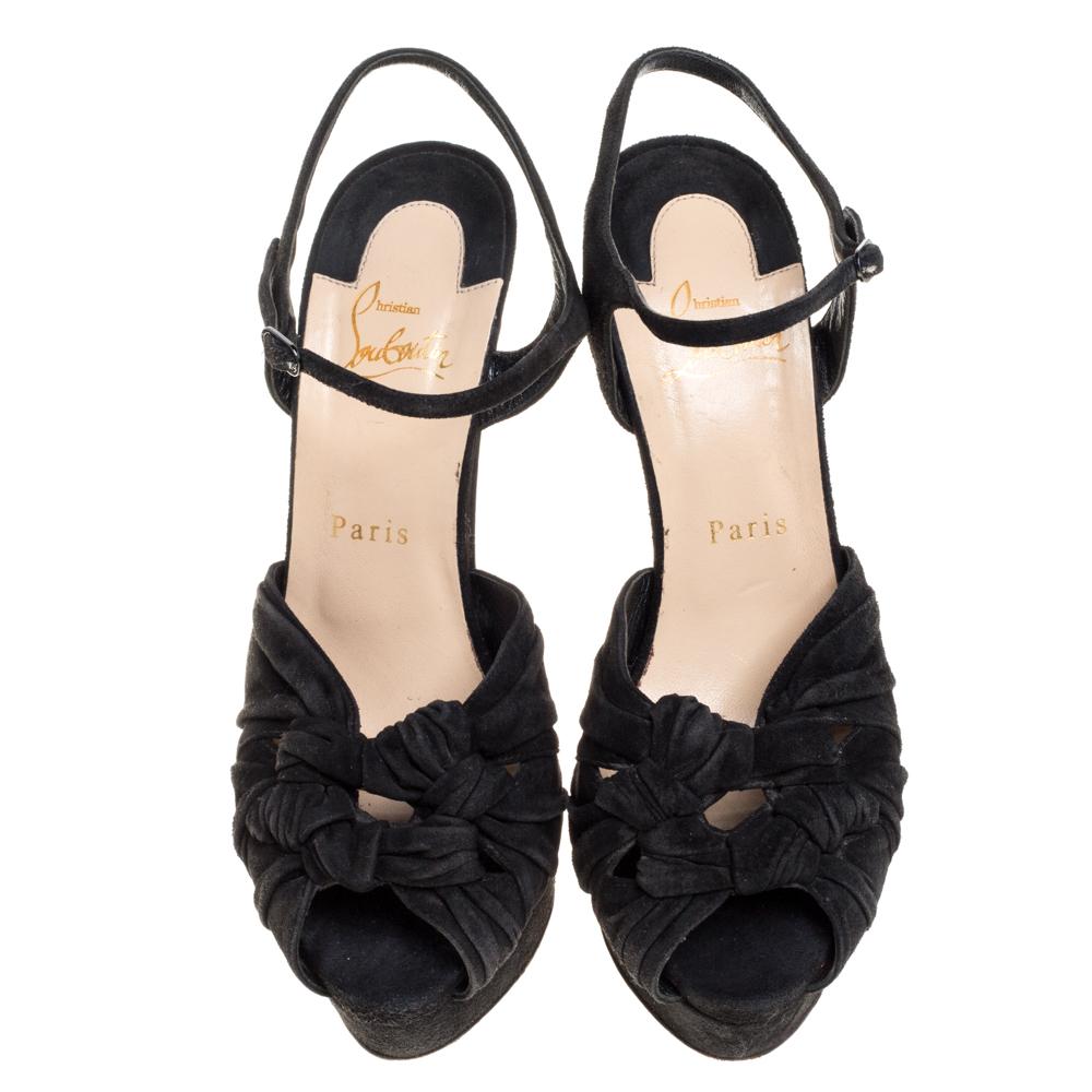 These stylish and versatile sandals come from the house of Christian Louboutin. Crafted meticulously from suede, they come in a classic shade of black. They are styled with peep-toes, platforms, knotted uppers, buckled ankle straps, 14.5 cm heels,