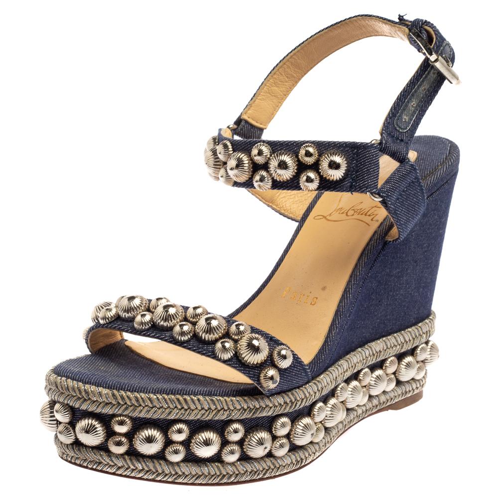 A blend of style and comfort, these Rondaclou sandals are an eye-catching pair. A Christian Louboutin design, this denim fabric pair is designed with textured studs in silver-tone metal. Set on wedge heels and the signature red soles, the sandals