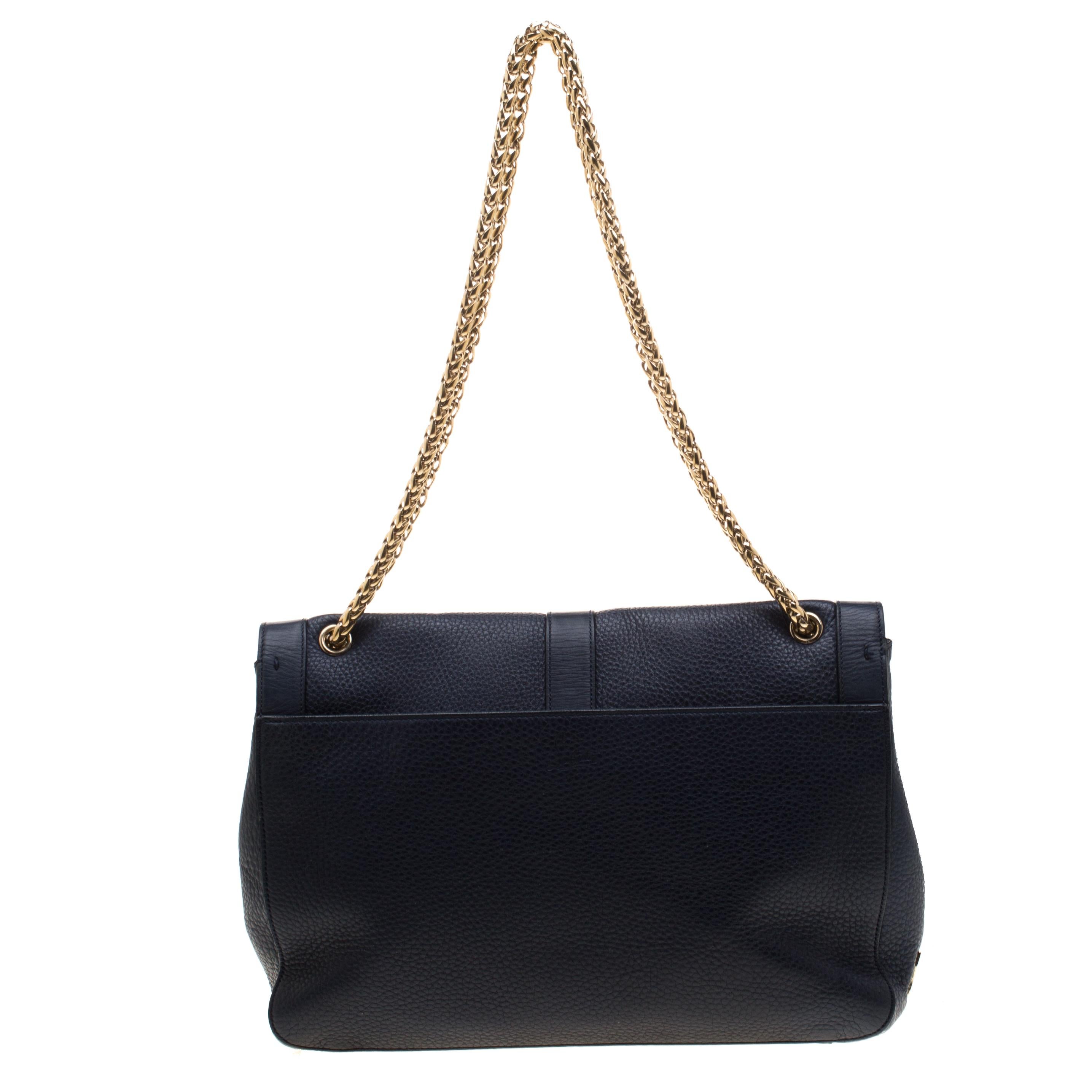 This modern Sweet Charity bag is a classic creation from Christian Louboutin. Crafted from blue leather, the bag comes with eye-catching stud embellishments and the signature Loubi bow detail on the front. The insides are fabric-lined and the bag is