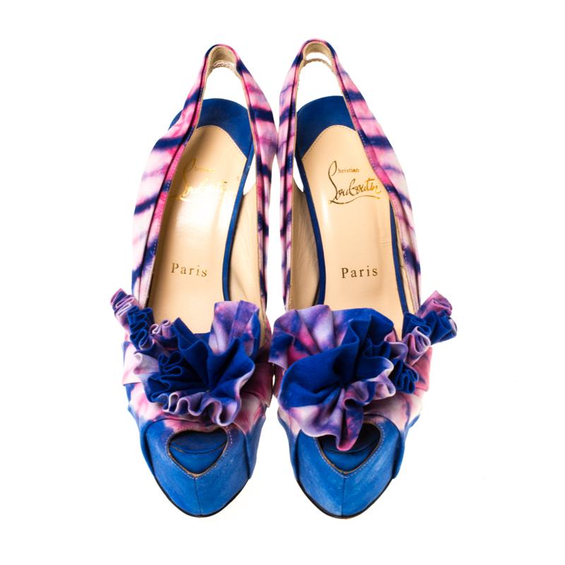 Light up any place with high-fashion when you step out in this sophisticated pair of Louboutins! Crafted from blue and pink fabric, the sandals have been designed with ruffles over the peep toes and slingbacks to hold the feet. The fabulous pair is