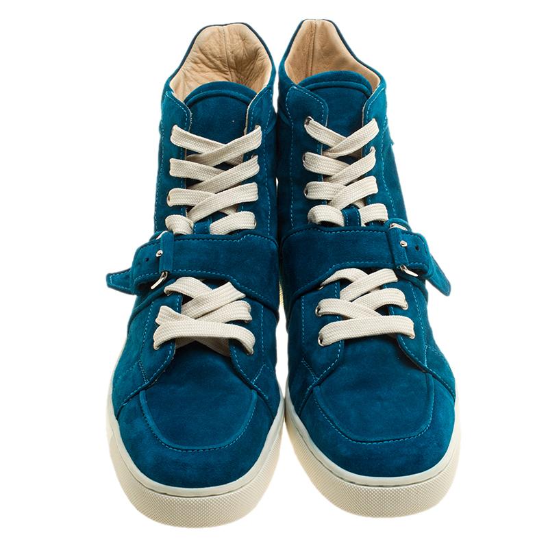Fashioned to take your style a notch higher, these blue sneakers from Christian Louboutin are absolutely worth the dream and the splurge! They've been crafted from suede and styled with laces on the vamps, belt details and the signature red