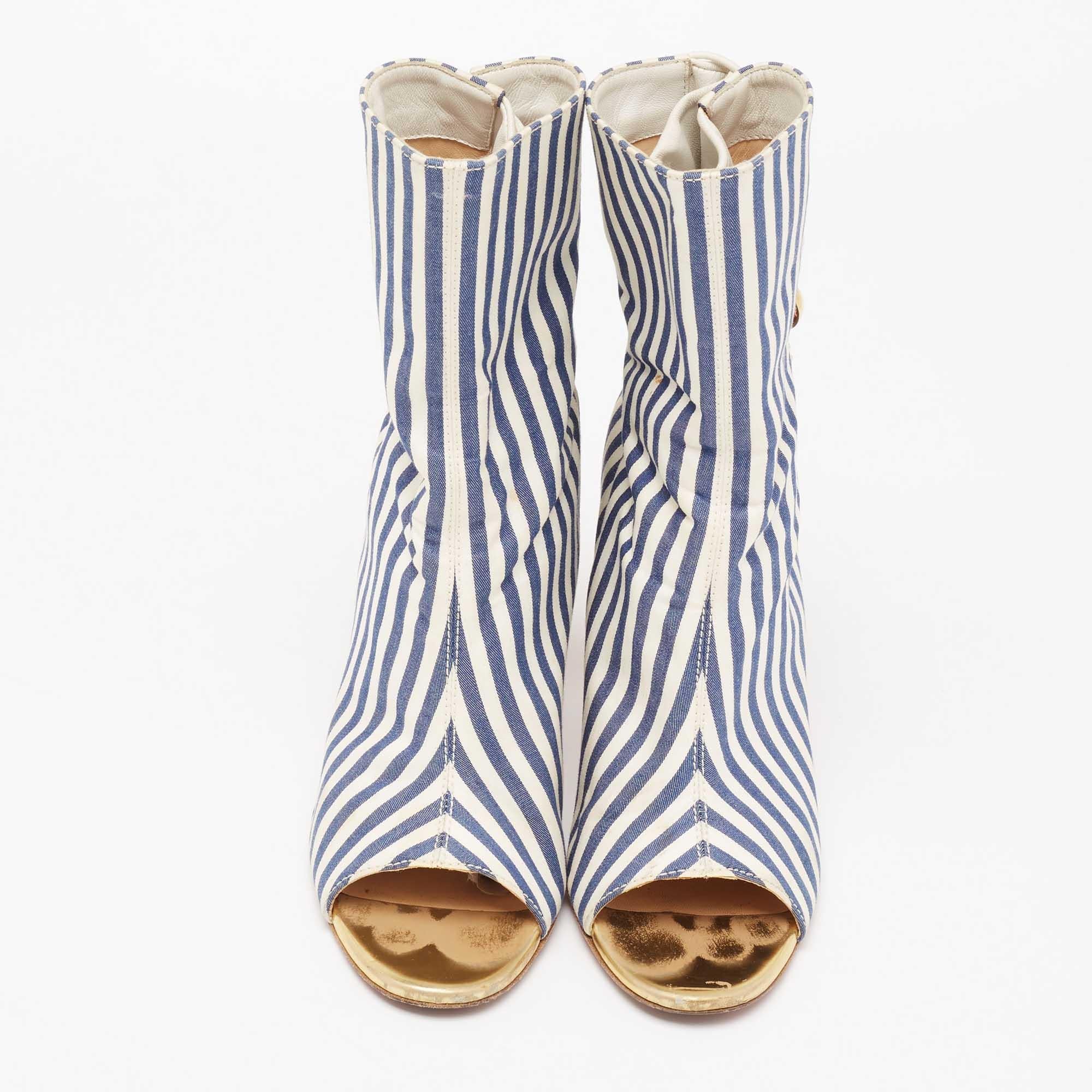 The blue and white stripe derailing make these Christian Louboutin boots striking. Crafted from fabric and leather, they are distinct with a loop button closure at the back and are balanced on 8cm heels for a perfect height. The signature