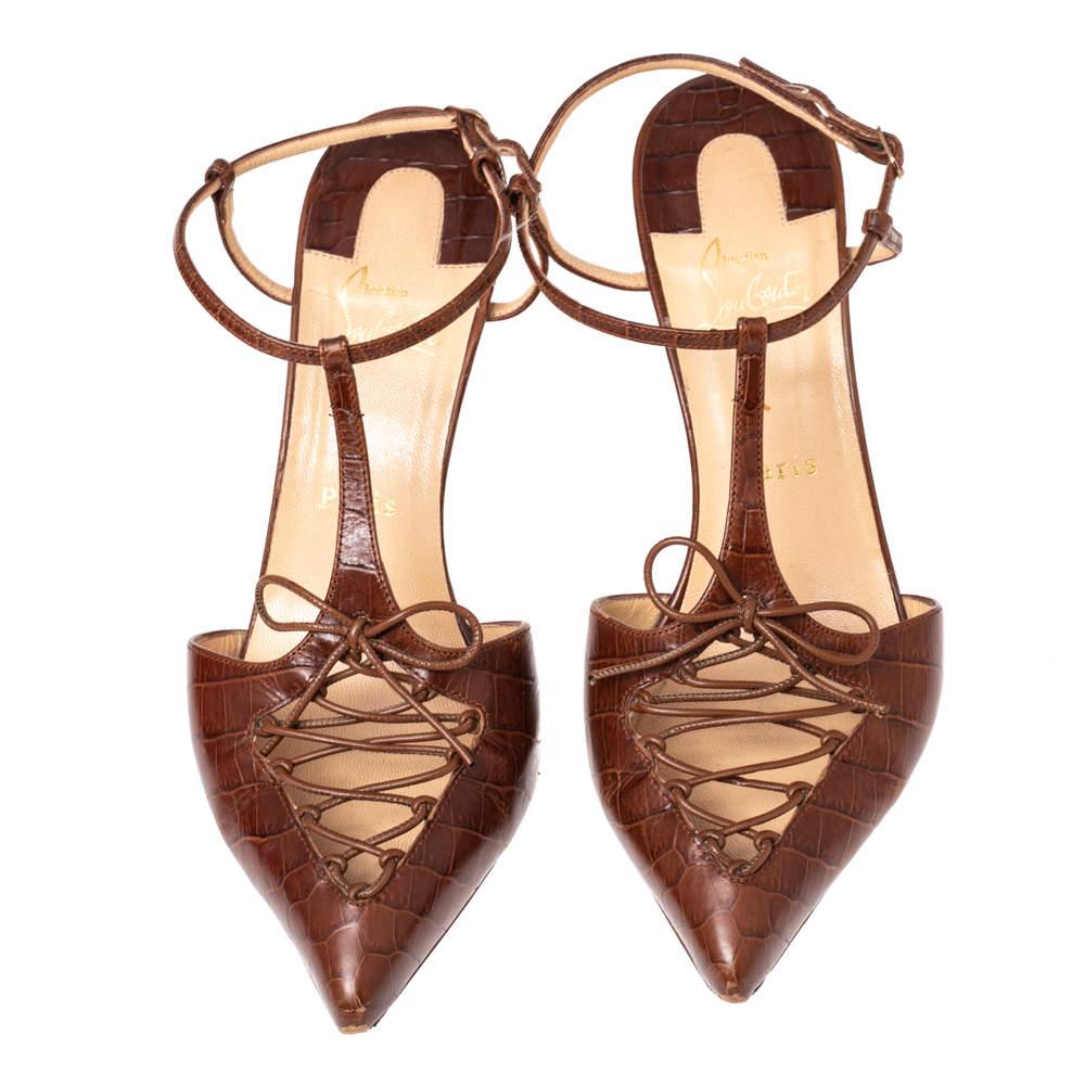 Finely crafted from brown croc-embossed leather in a T-strap style, these Christian Louboutin pumps will frame your feet beautifully. The sandals feature pointed toes, upper lace details, buckle ankle fastenings, and 8.5 cm heels.

Includes: