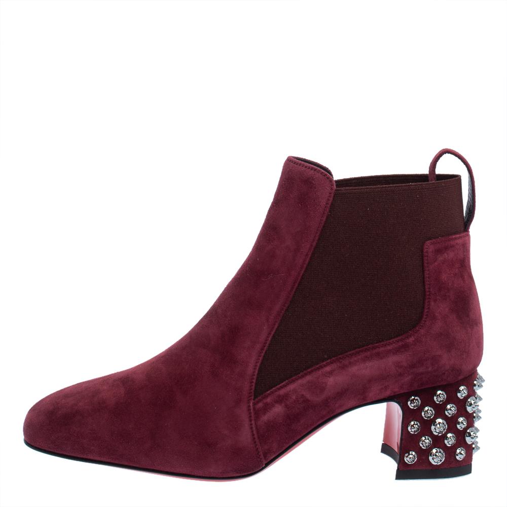 Everything about this pair of boots is edgy. From the house of Christian Louboutin, these ankle boots are for women who like trendy fashion. They have been fabulously crafted in a classic silhouette with suede in a burgundy hue. The pair is accented