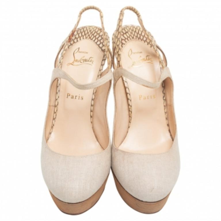 These Fine Bretelle pumps are an everlasting creation originating from the iconic House of Christian Louboutin. The enthralling silhouette of these pumps is characterized by a beige canvas and snakeskin exterior, platforms, slingback, and the red