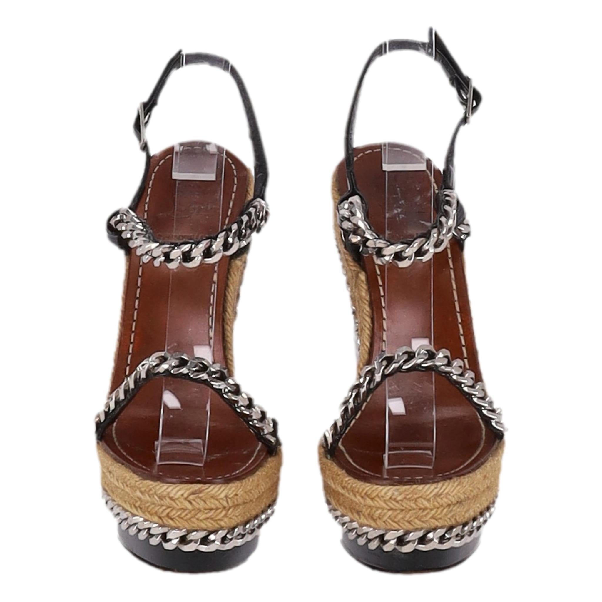 Christian Louboutin - Sandales à semelles compensées en raphia avec détails de chaînes

Sandales compensées noires avec chaîne argentée et finitions en espadrille beige.

Il est doté de brides en cuir verni rehaussées de chaînes et d'une bride de