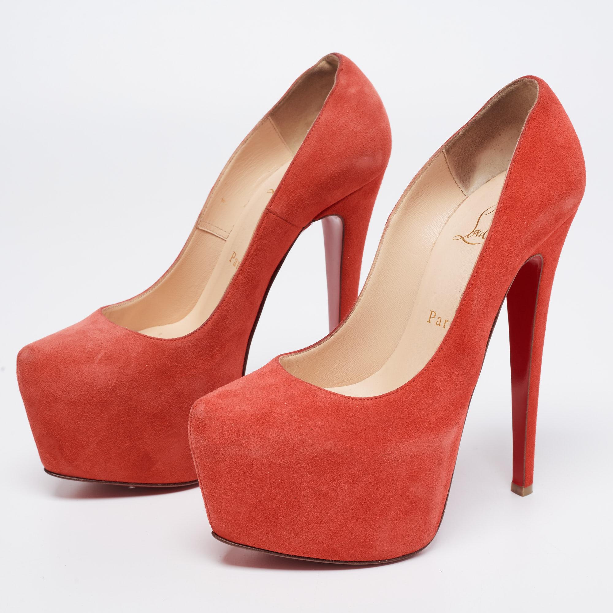 These gorgeous platform pumps from Christian Louboutin epitomize the concept of high fashion. They are crafted from coral red suede and designed with chunky platforms. The pumps are equipped with comfortable leather-lined insoles and are elevated on