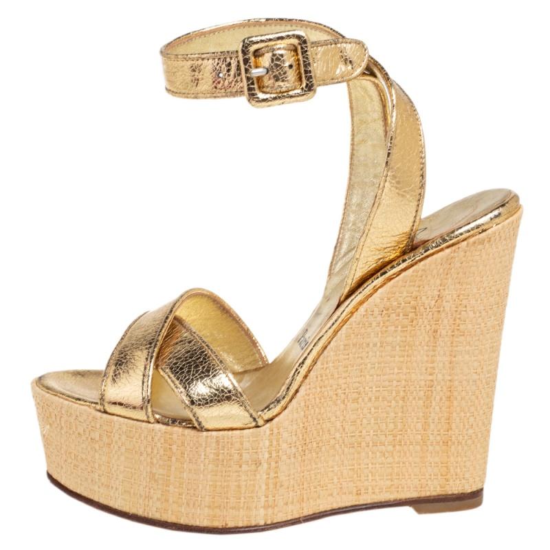 Walk like a runway model in this stunning pair of wedges from Christian Louboutin. With a leather exterior, these metallic gold sandals feature stylish cross straps that lend an overall regal vibe. Leather insoles and buckle closures make for