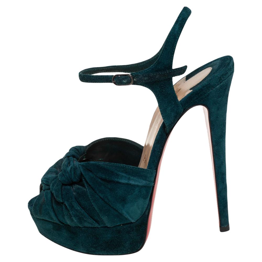 These stylish and versatile sandals come from the house of Christian Louboutin. Crafted meticulously from suede, they come in an alluring shade. They are styled with peep-toes, platforms, knotted uppers, buckled ankle straps, 14 cm heels, black-tone