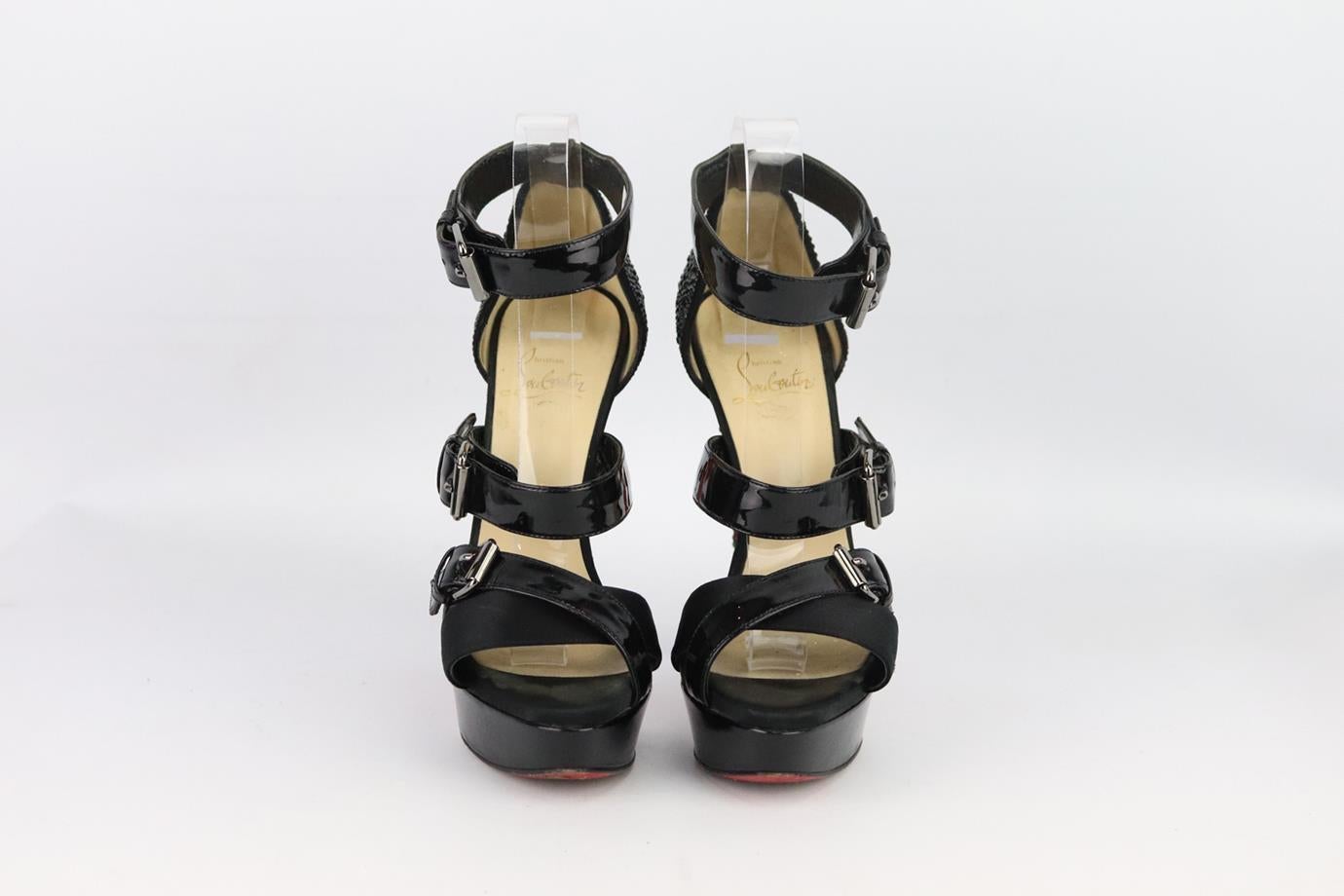 Christian Louboutin embellished patent leather platform sandals. Made from black patent leather and satin with crystal embellished heel with buckle detail and set on the brand’s iconic red sole. Black. Buckle fastening at side. Does not come with
